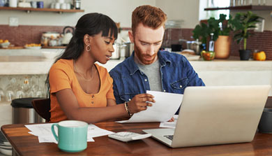 Couple reviewing paperwork at kitchen table