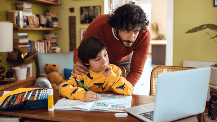 man helping his kid with the online class