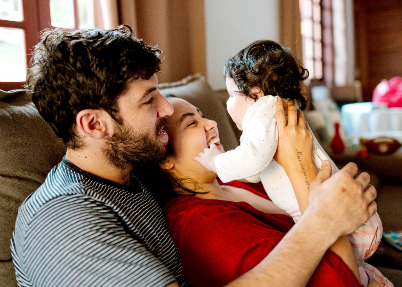Dad, Mom, and baby sitting on the couch