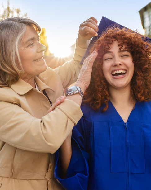 Mom assisting daughter with her graduation cap